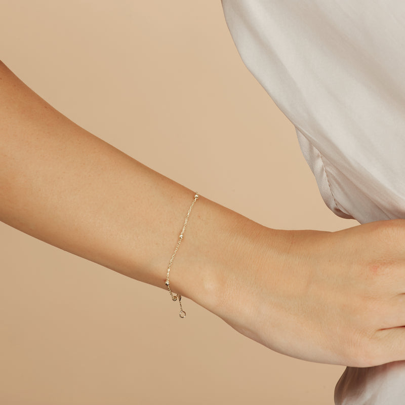 The Basic Ball Bracelet for day to night wear is made of 14 karat gold. The bracelet features solid gold balls aligned on a delicate gold chain.