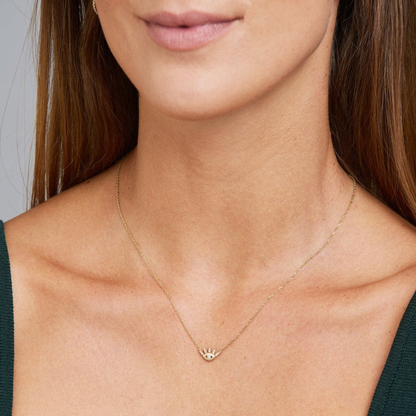 This 14 karat gold evil eye diamond necklace is our dream jewelry piece. The gold pendant necklace features pave set diamonds on the lashes and a bigger diamond stone in the center of the eye.