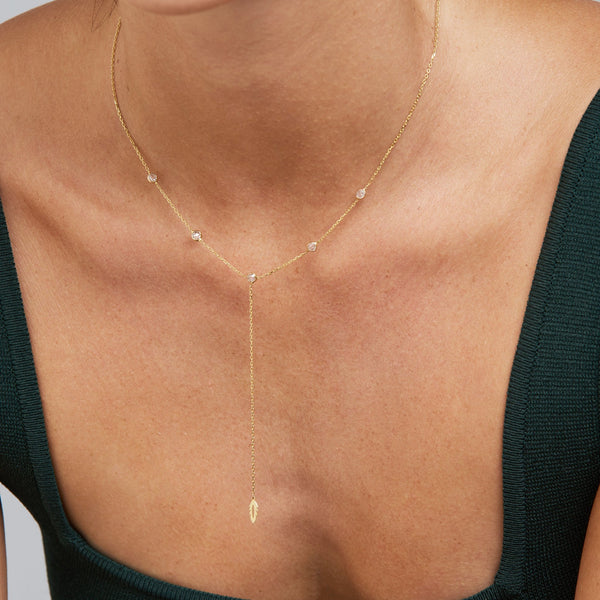 The enchanting 14 karat gold Feather Y Necklace features a feather perched along the bezel-set stone necklace. Each sparkling diamond cut stone is bezel set in 14k gold.   A beautiful gold charm necklace to wear day and night. This elegant necklace is one of our bestsellers and will not go unnoticed as its stones are sparkling around your neck.