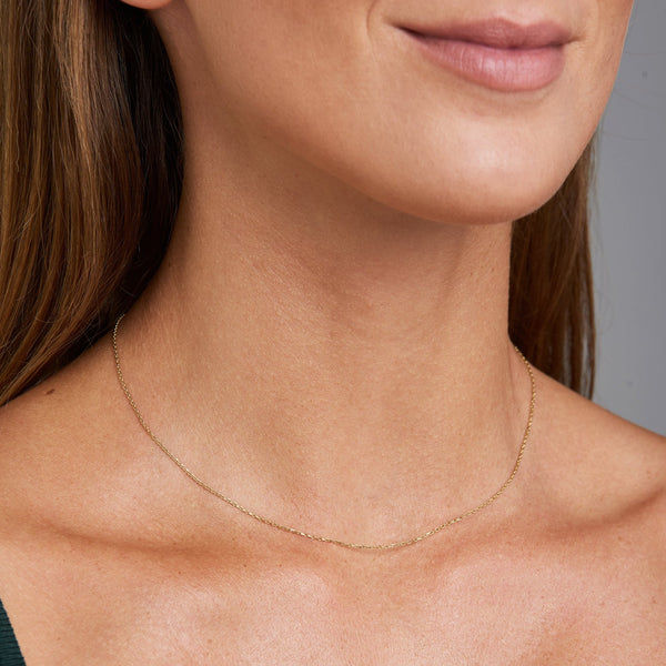 This fine 14 karat gold necklace is the ultimate statement of minimalism. It is the perfect gold necklace for women who love to layer jewels. 