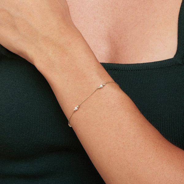 This handmade 14 karat gold pearl bracelet is an essential classic for every day. Each freshwater pearl is encased by diamond cut gold balls that reflect the light and add an extra sparkle to your wrist. 