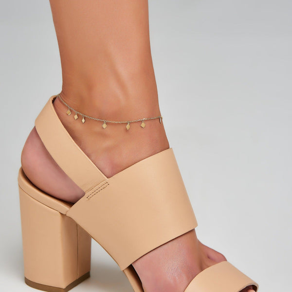 This delicate and playful gold anklet features dangling tribal gold charms. Its simple style mixes and matches easily with other jewels and is the perfect accessory for a boho- glam look.