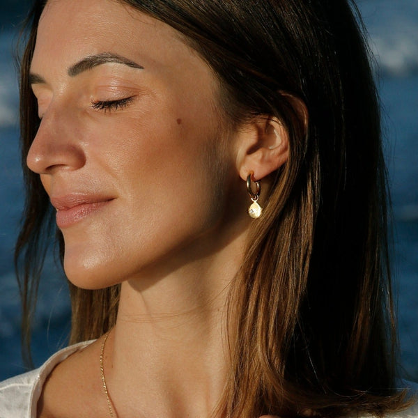 A delicate yet glamorous pair of gold earrings. The Penelope Earrings feature a white topaz stone and imbue you with magic and sparkle. Team these earrings with an Essential Gold Necklace from our collection or the Birthstone Necklaces.